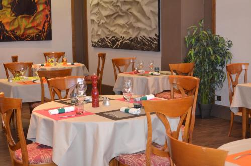 una sala da pranzo con due tavoli con tovaglie bianche di Hotel La Poularde a Gien