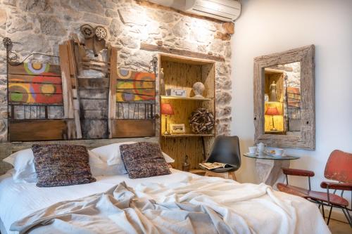 a bedroom with a bed and a stone wall at Amymone and Adiandi in Nafplio