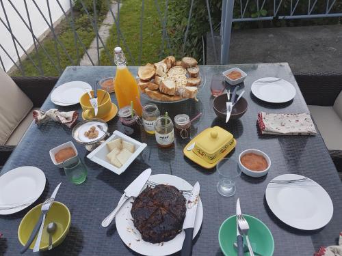 a table with plates of food and drinks on it at Chambres d'hôtes Chez Valérie Garage motos et vélos in Arette