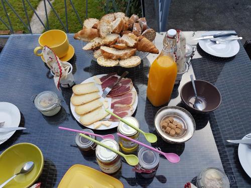 a picnic table with a bunch of food and orange juice at Chambres d'hôtes Chez Valérie Garage motos et vélos in Arette
