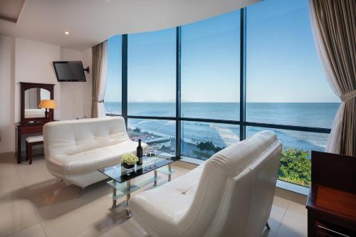 a living room filled with furniture and a view of the ocean at Corvin Hotel in Vung Tau