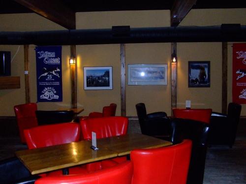 a dining room with red chairs and a wooden table at The Yukon Inn in Whitehorse