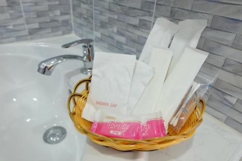 a basket of toiletries sitting on a bathroom sink at Airport Pearl Residence in Nai Yang Beach
