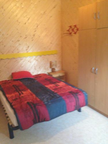 sypialnia z łóżkiem z czerwonym kocem w obiekcie Les Marmottes w mieście Excénevex