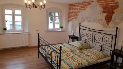 een slaapkamer met een bed en een bakstenen muur bij Ferienwohnung Trogschneider Hof in Erbendorf