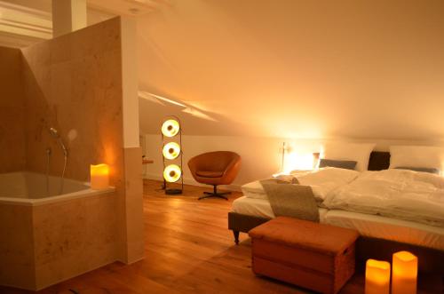 ein Schlafzimmer mit einem Bett und ein Badezimmer mit einer Badewanne in der Unterkunft Eifelsuite in Birresborn