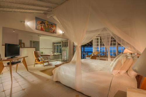 a bedroom with a bed with a canopy at Pousada Enseada das Garças in São Pedro da Aldeia