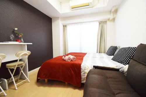 um pequeno quarto com uma cama e um sofá em Square Shibuya 407 em Tóquio