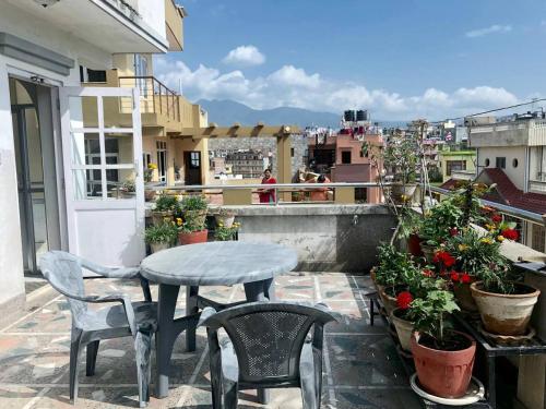 a patio with a table and chairs on a balcony at KAJI HOME in Pātan