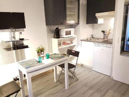 une petite cuisine avec une table et des chaises blanches dans l'établissement Bandol Brothers, à Bandol