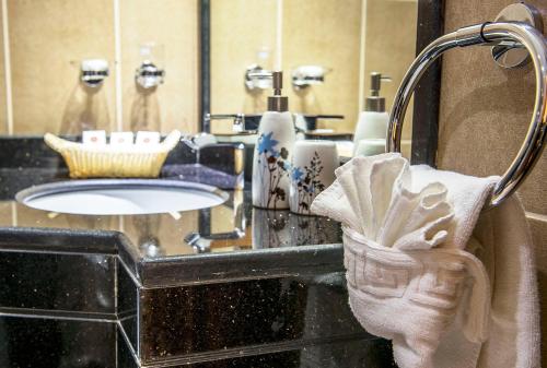 a bathroom with a sink and a towel at Hala Inn Hotel Apartments - BAITHANS in Ajman 