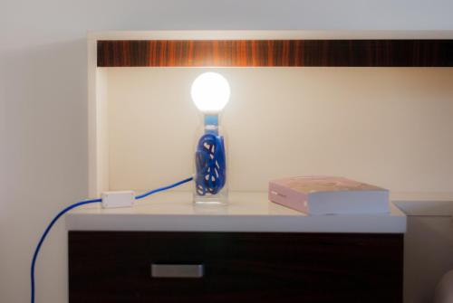 a lamp sitting on a table next to a book at Haus Kuen in Merano