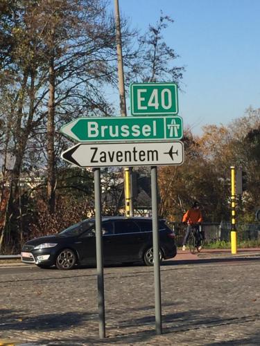 a street sign on the side of a road with a car at FANTASIA a spacious beautiful apartment & affordable in Nossegem