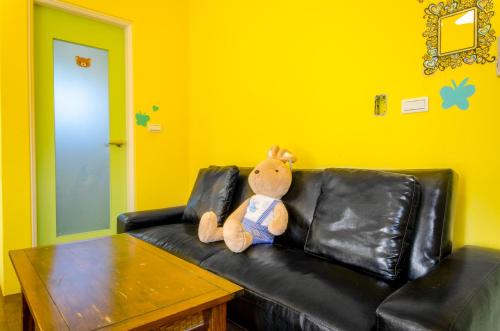 a teddy bear sitting on a leather couch at 梅花湖-陽光屋民宿 in Dongshan