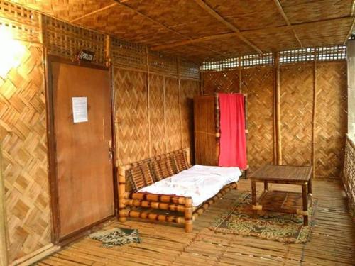 MajuliにあるRisong Family Guest Houseのベッドとテーブルのある小さな部屋