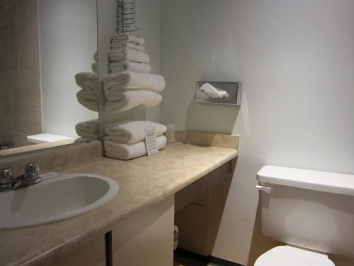 a bathroom with a sink and a toilet and towels at Moby Dick Inn in Prince Rupert