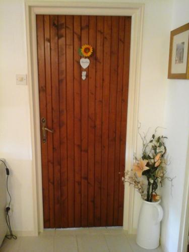 a wooden door with a vase of flowers in front of it at La Maison Des Fleurs in Montembœuf