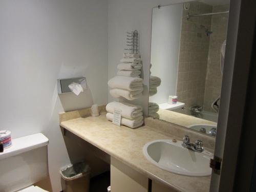 a bathroom with a sink and a mirror and towels at Moby Dick Inn in Prince Rupert