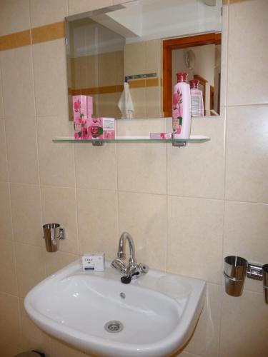 a bathroom with a sink and a mirror at BALATON ART Apartman in Balatonszemes