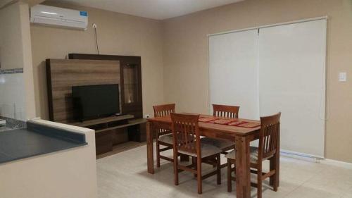 a dining room with a table and chairs and a television at ALQUILER TEMPORARIO VILLA UNION in Villa Unión