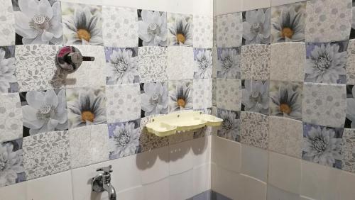 a bathroom with a sink and flowers on the wall at Best Kerala Homestay in Kattappana