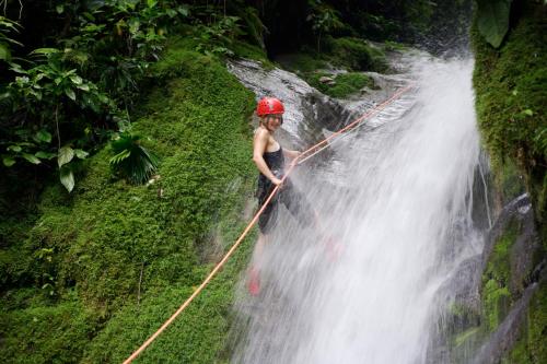 a woman standing on a rope on top of a waterfall at Selva Bananito Lodge in Westfalia
