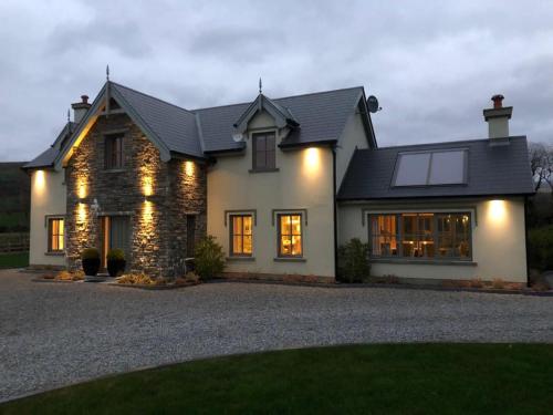 a house with lights on the front of it at Beechwood 4, Kenmare Luxurious Living in Killowen