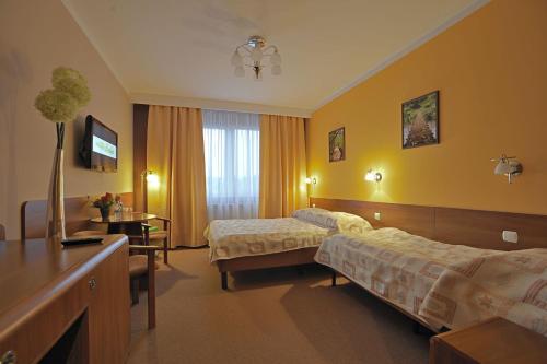 a hotel room with two beds and a television at Hotel Baranowski in Słubice