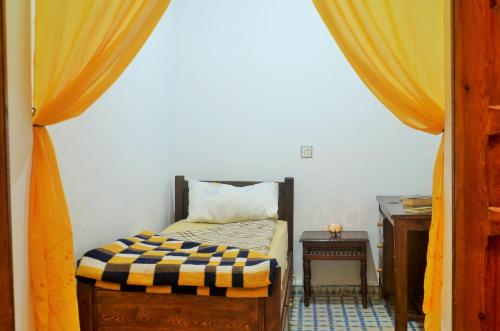 a small bedroom with a bed and a table at Moroccan Dream Hostel in Fès