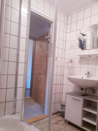 a bathroom with a shower and a sink at Hotel & Restaurant Gulfhof in Emden