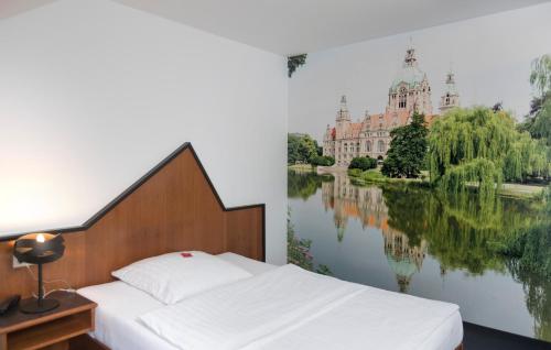 une chambre avec un lit et une peinture d'un bâtiment dans l'établissement Hotel Apartment Laforsch, à Dreieich