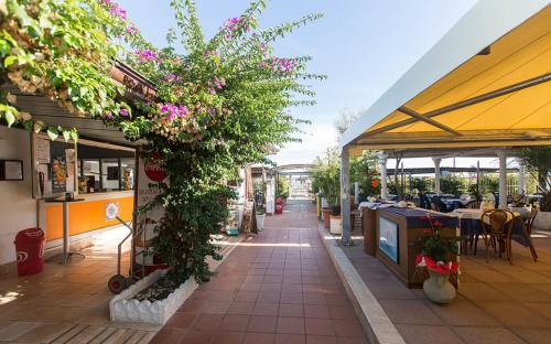 un patio con flores y mesas en un restaurante en Hotel Anna, en Terracina
