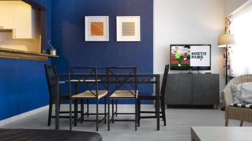 ein Esszimmer mit einer blauen Wand sowie einem Tisch und Stühlen in der Unterkunft Apartment Valdemosa in De Haan