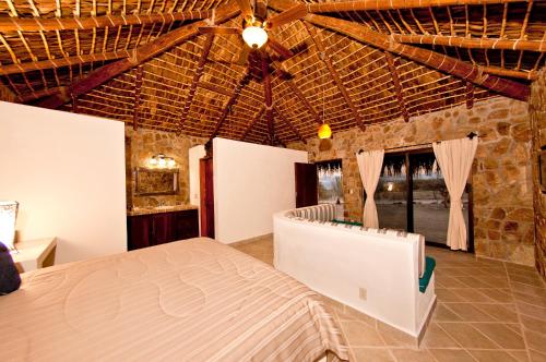 a bedroom with a bed and a laptop in a room at Palapas La Choya in La Ventana