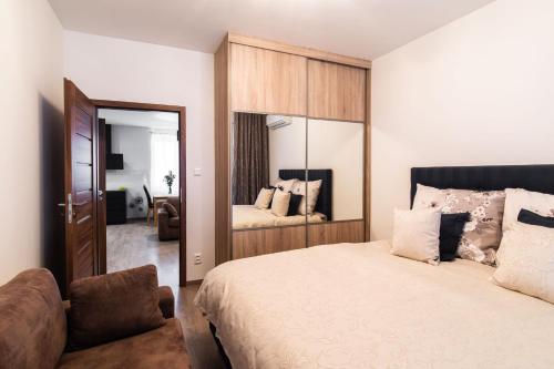 - une chambre avec un lit, une chaise et un miroir dans l'établissement Newly renovated, Full Equipped and Quiet Apartment, à Trnava