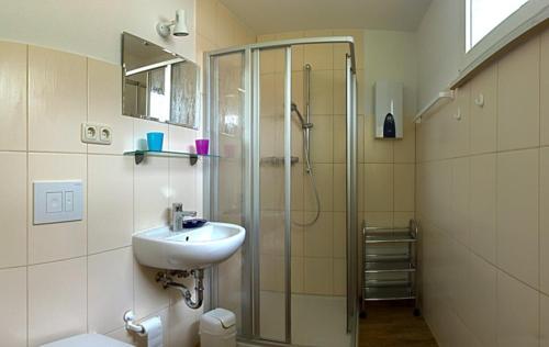 a bathroom with a shower and a sink and a shower at Uns' Husing in Marienfelde