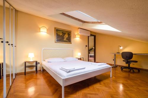 ボローニャにあるS.Orsola Apartmentsのベッドルーム(白いベッド1台、デスク付)
