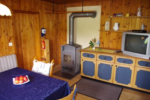 a living room with a table and a wood stove at Ferienhaus Forellenwirt in Grünbach