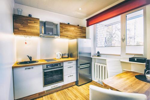 Il comprend une cuisine équipée d'un réfrigérateur et d'une table. dans l'établissement Simoone Kesklinna Apartment, à Haapsalu