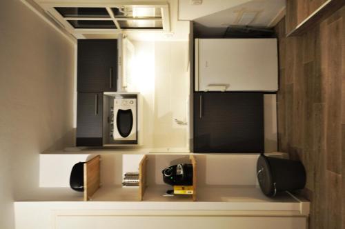 une petite cuisine avec un micro-ondes et une cuisinière dans l'établissement Studio tiny et cosy quartier St Etienne, à Toulouse