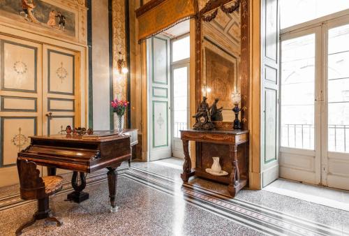 a room with a piano and a table in it at Palazzo Framarino dei Malatesta - Noble Floor - XIV Century in Giovinazzo