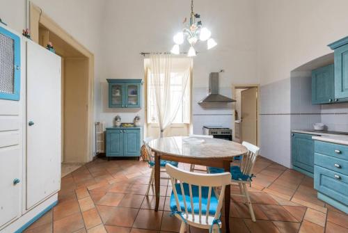 a kitchen with blue cabinets and a table and chairs at Palazzo Framarino dei Malatesta - Noble Floor - XIV Century in Giovinazzo