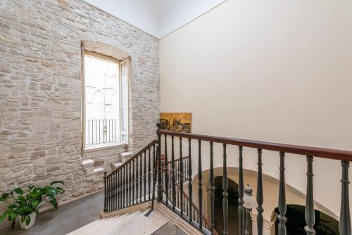 a staircase with a brick wall and a window at Palazzo Framarino dei Malatesta - Noble Floor - XIV Century in Giovinazzo