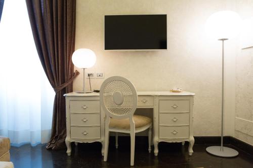 a room with a desk with a chair and a mirror at Palazzo Favacchio - Patanè in Scicli