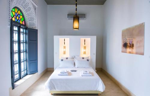 a bedroom with a bed and a stained glass window at Riad Yamcha in Meknès