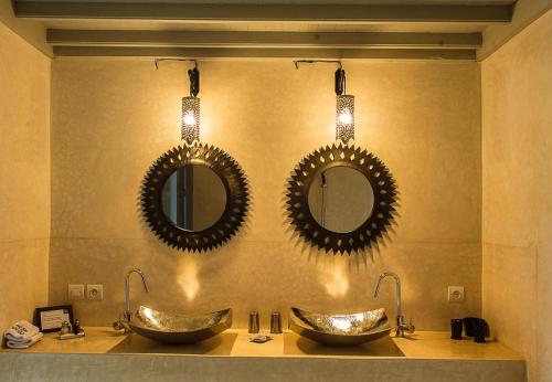 a bathroom with two sinks and two mirrors on the wall at Riad Yamcha in Meknès