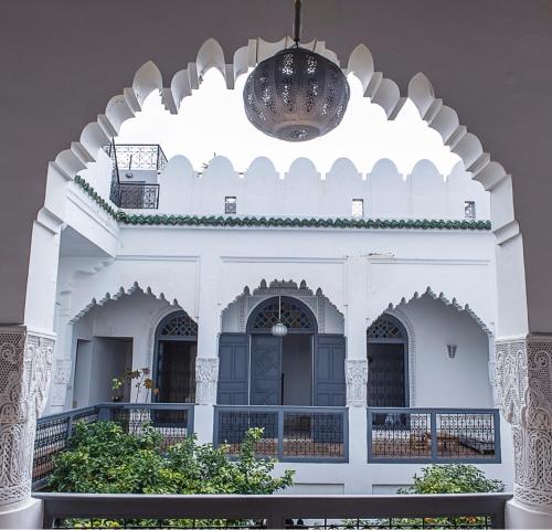 a white building with a chandelier above it at Riad Yamcha in Meknès