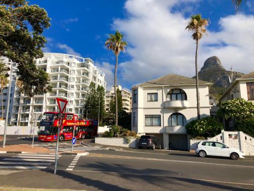 a red double decker bus parked in front of a building at Prince Edward Mansions in Cape Town