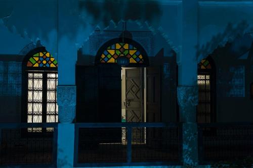 a painting of a building with two windows and a door at Riad Yamcha in Meknès