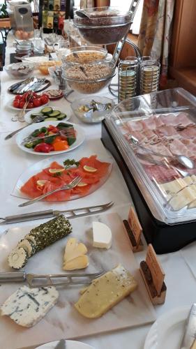 a table topped with plates of food and cheese at Edelsteinhotel Guniwirt in Krakaudorf